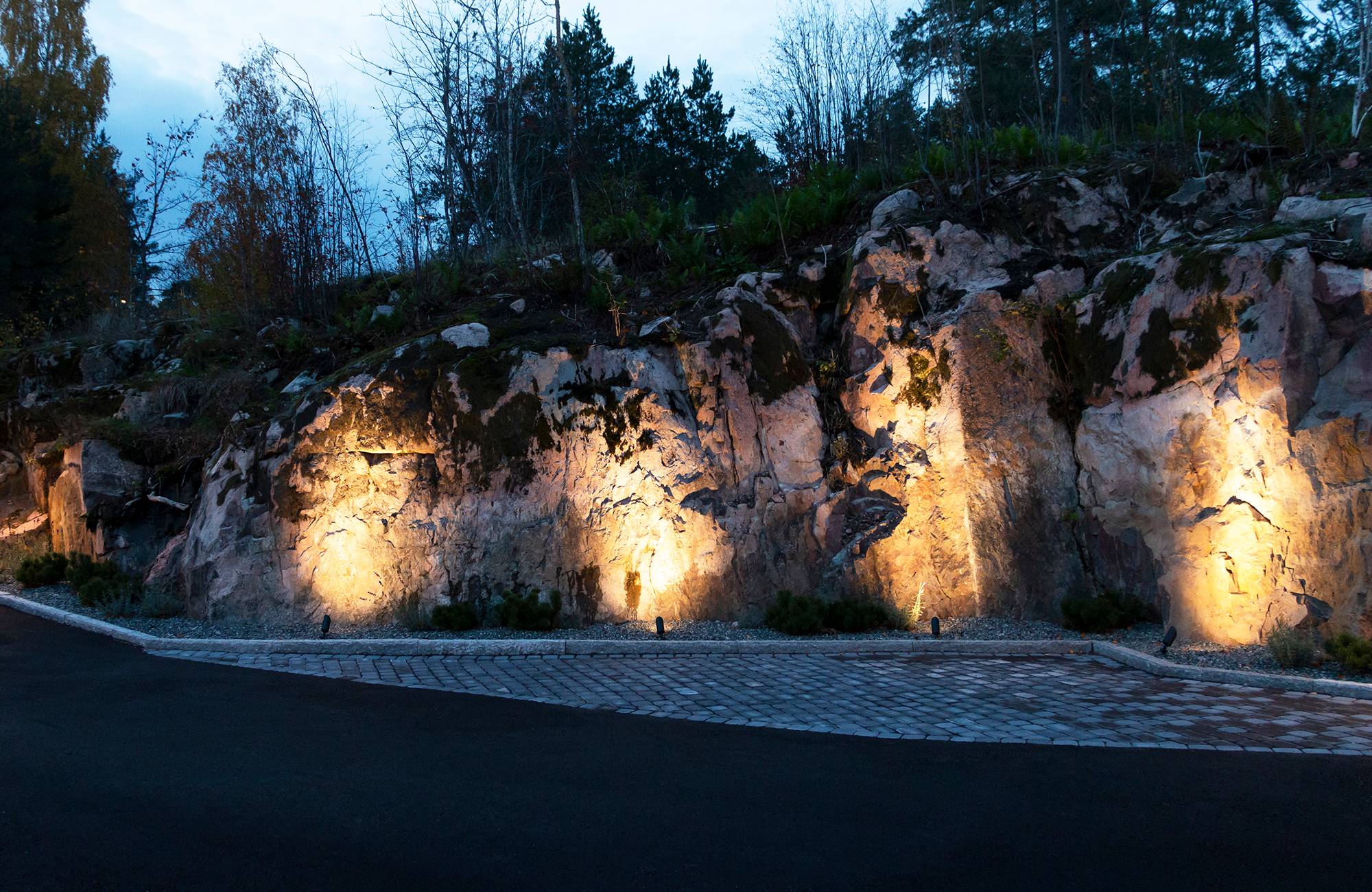 Venku, akcentní osvětlení útesu s hliněnými nádobami. Ledstore.fi